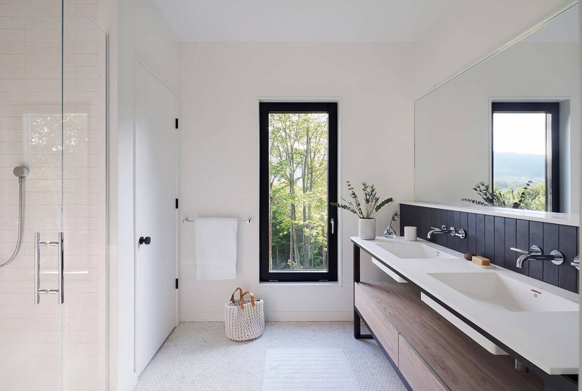 Modern farmhouse primary bathroom with double vanity, penny tile floor and Green Mountain views in Vermont