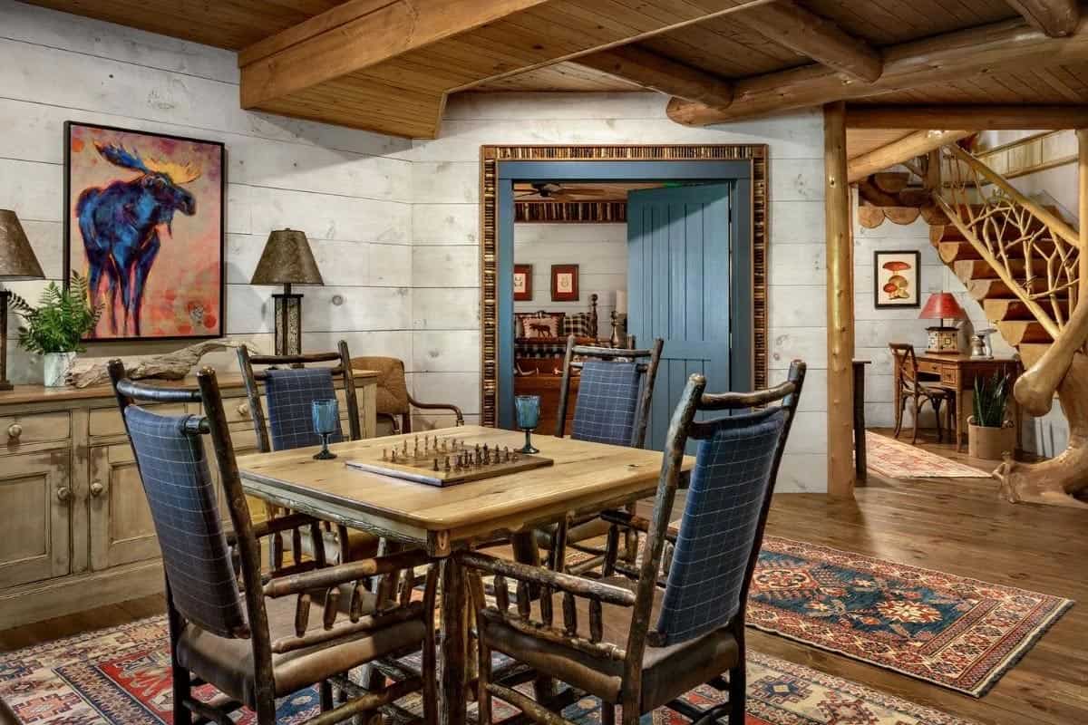 Lower level game room with hickory chess table, colorful moose painting, and log staircase