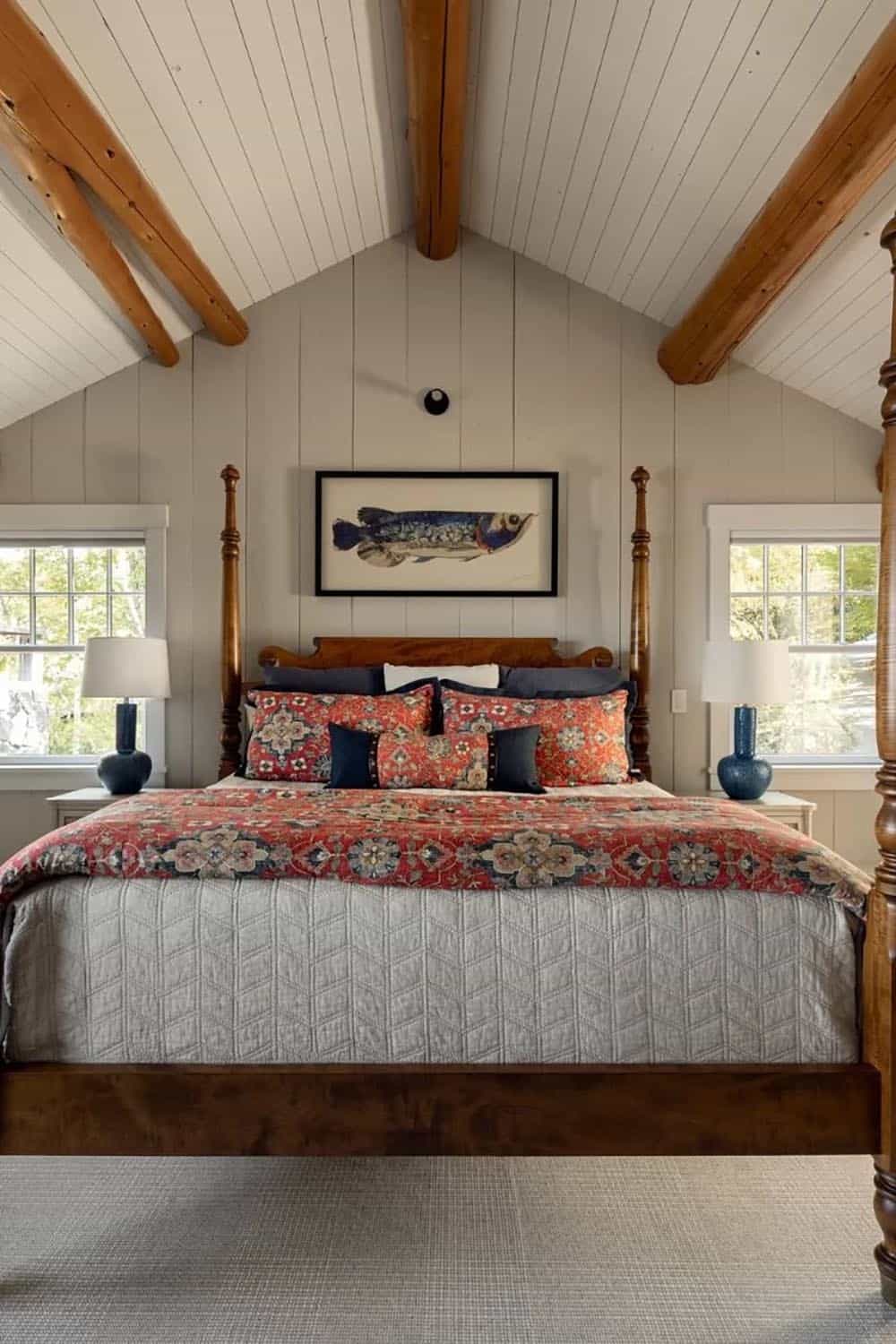 Guest bedroom with vaulted shiplap ceiling, four-poster bed, floral bedding, and vintage fish print