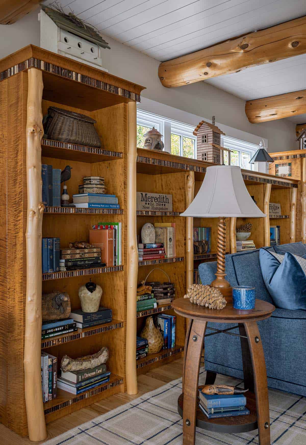 Rustic built-in bookcase with cedar log columns, birch trim, and New Hampshire lake house collectibles