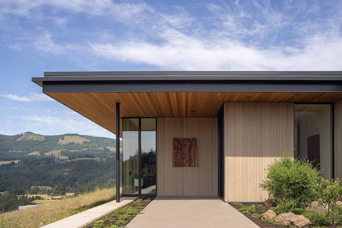 Entry walkway to a modern home with wood siding, cedar soffit, and mountain views