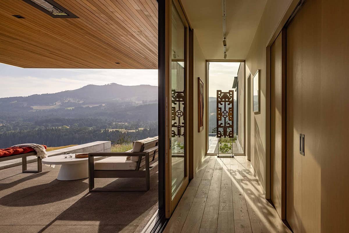 Hallway and open terrace with mountain views, decorative ironwork panels, and wood flooring