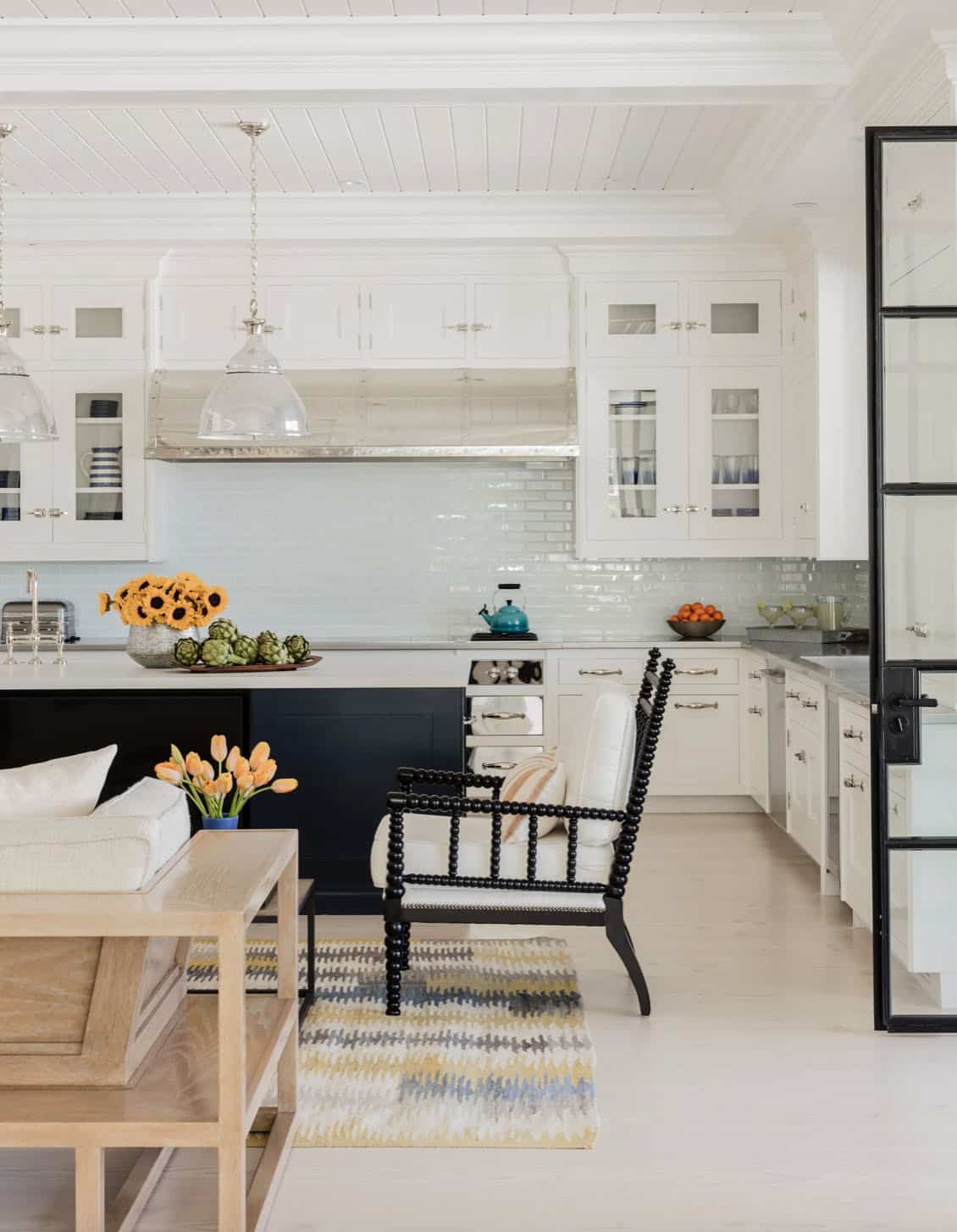Kitchen detail showing navy island, spindle accent chair, and ikat area rug