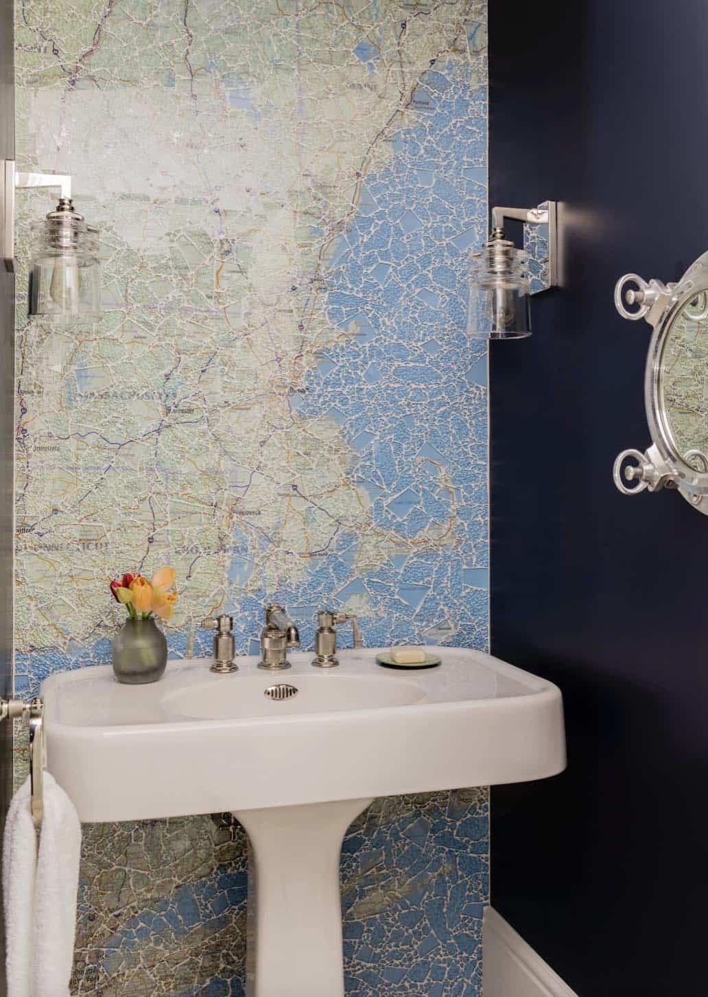 Powder room with large-scale map wallpaper, pedestal sink, and porthole mirror