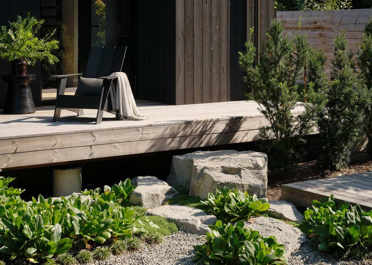 Close-up of floating wood deck with Adirondack chair, boulders, and ground cover plantings