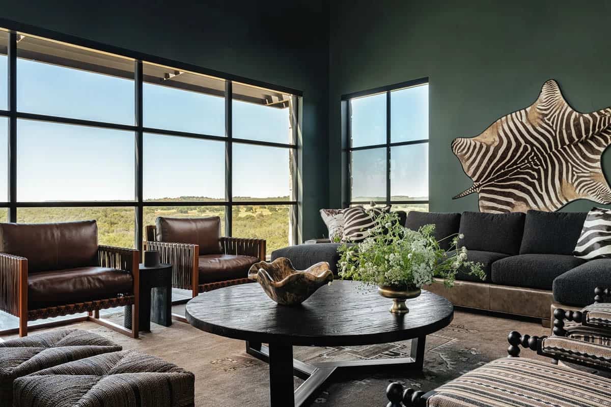 Dark green living room with leather chairs, zebra hide wall art and panoramic windows