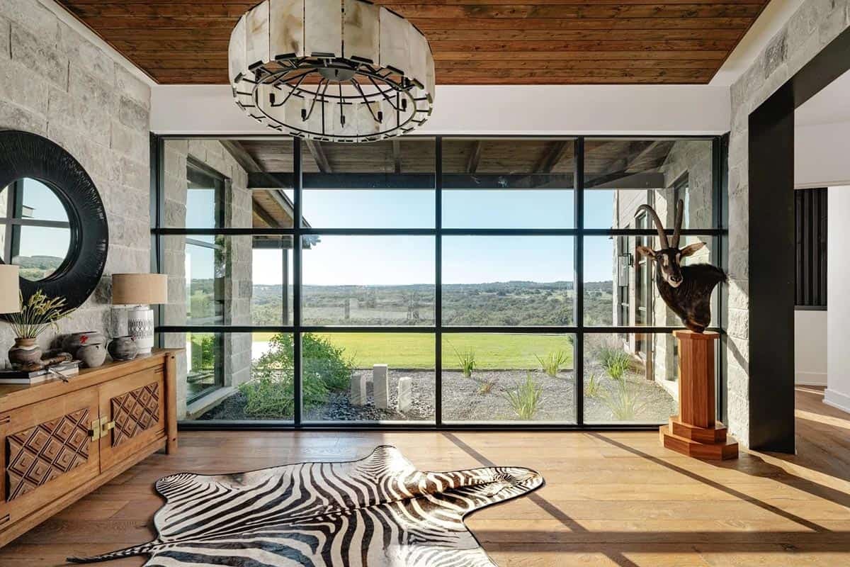 Foyer with floor-to-ceiling steel windows, capiz shell chandelier and sweeping ranch views