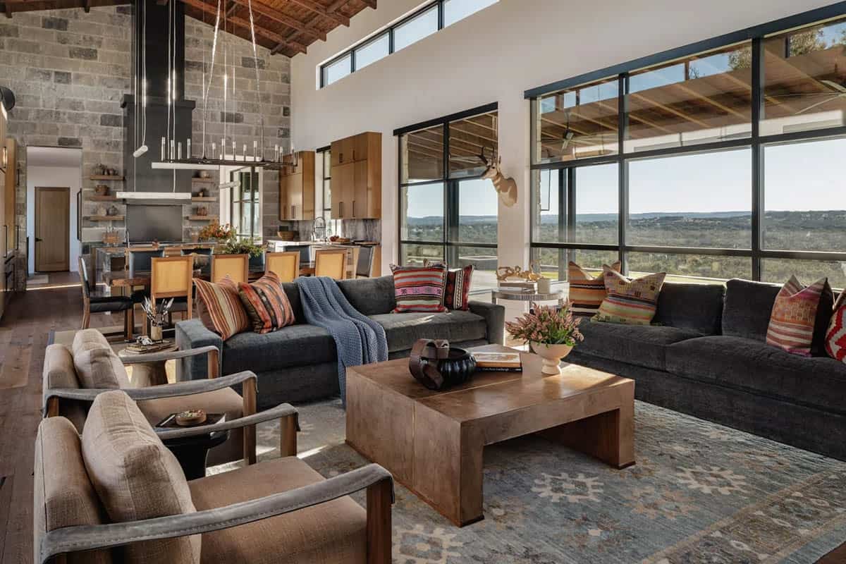 Open plan living room with stone walls, reclaimed wood ceiling and panoramic Hill Country views