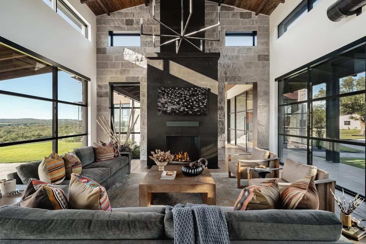 Great room with soaring limestone fireplace wall, steel chandelier and colorful kilim pillows