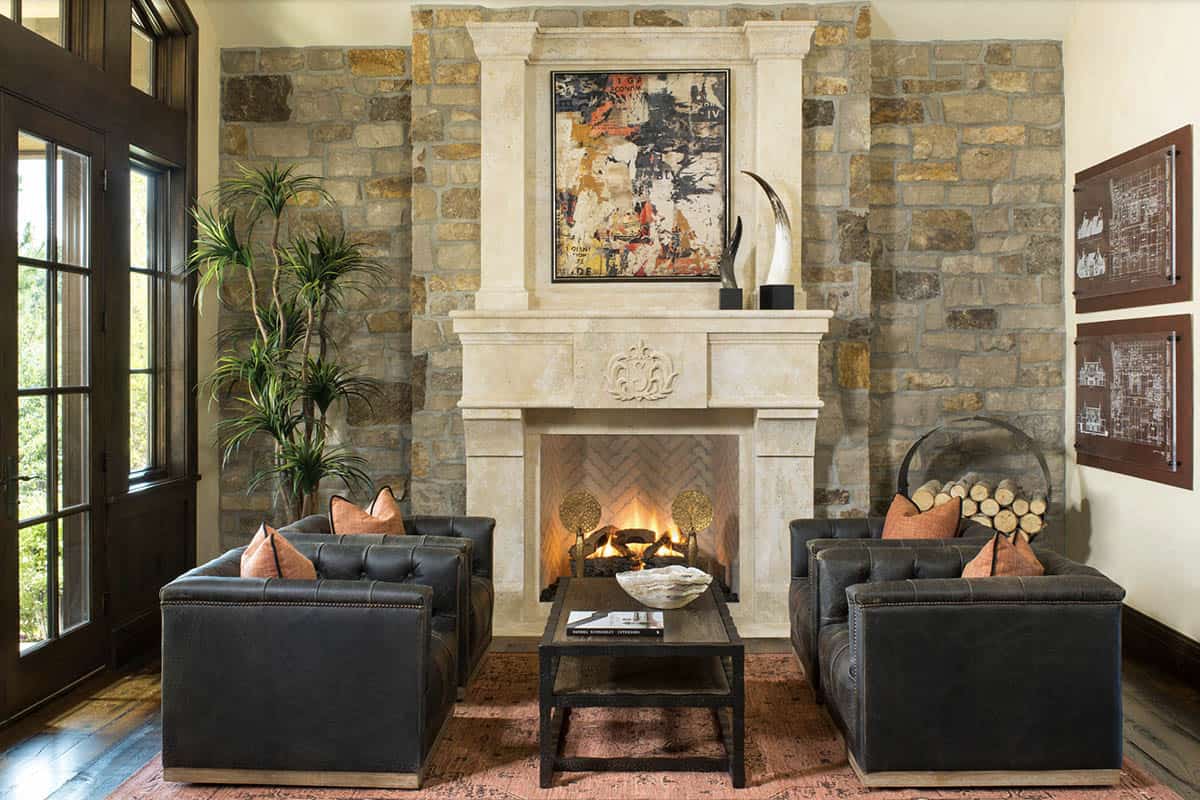 Stone fireplace with cast stone mantel and leather seating in sitting room