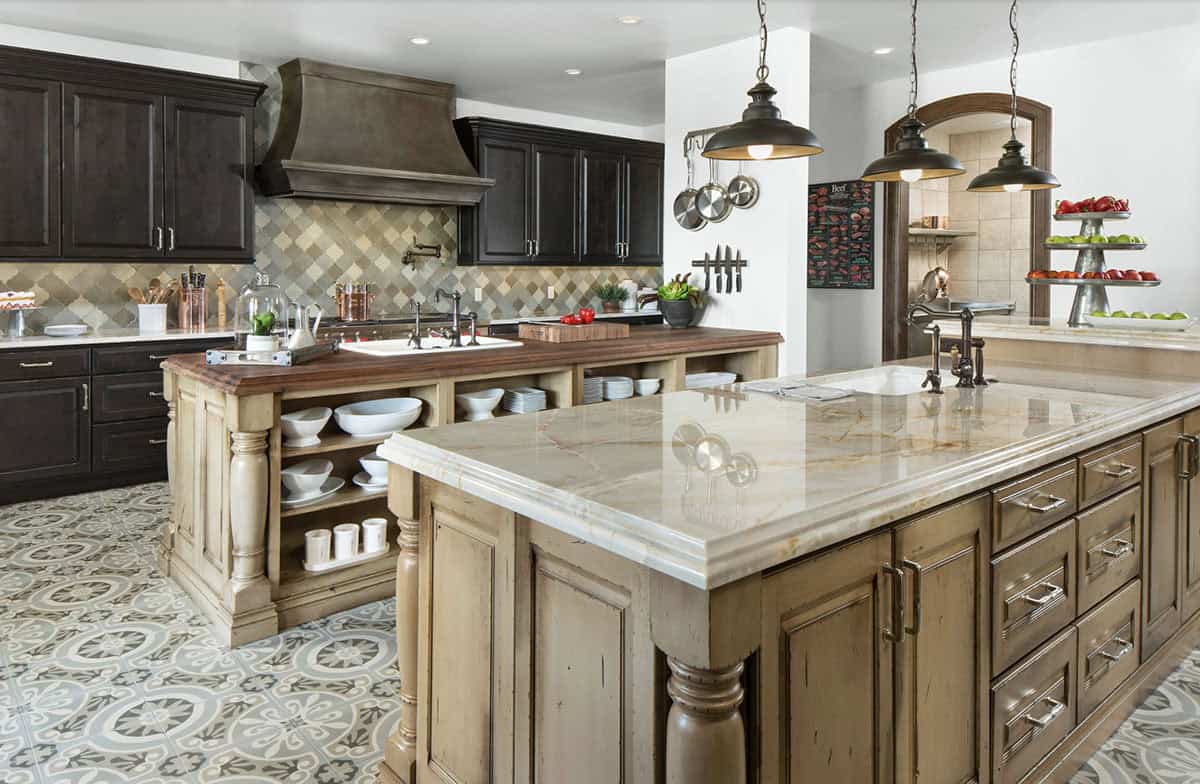 Gourmet kitchen with dual islands, patterned tile floor, and dark cabinetry