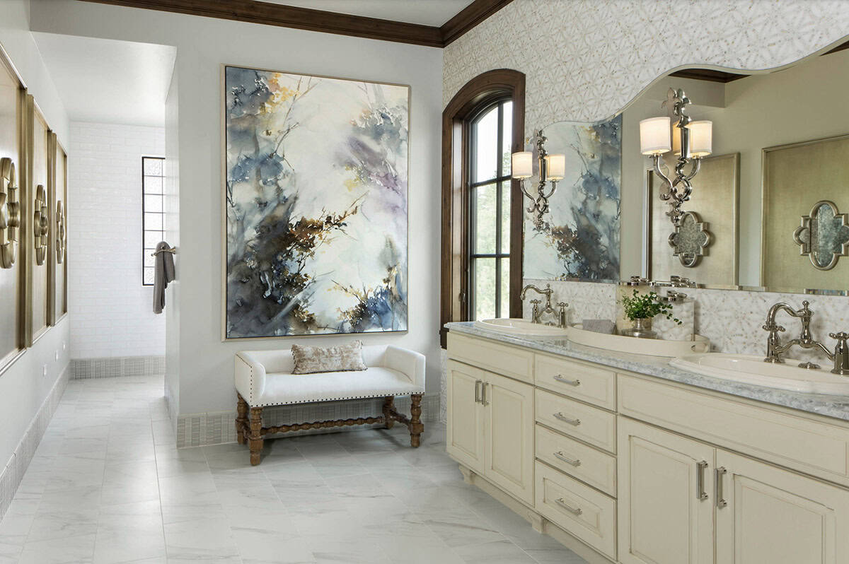 Primary bathroom with double vanity, marble countertops, and large-scale artwork