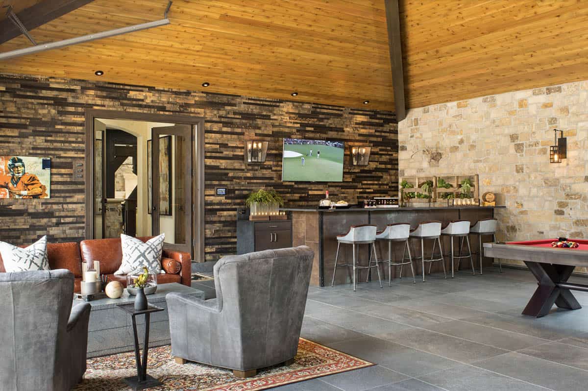 Garage entertaining bar with stone accent wall, pool table, and bar seating
