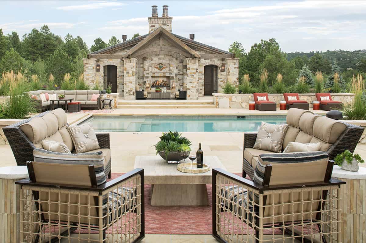 Pool house exterior with natural stone, outdoor fireplace, and pool deck