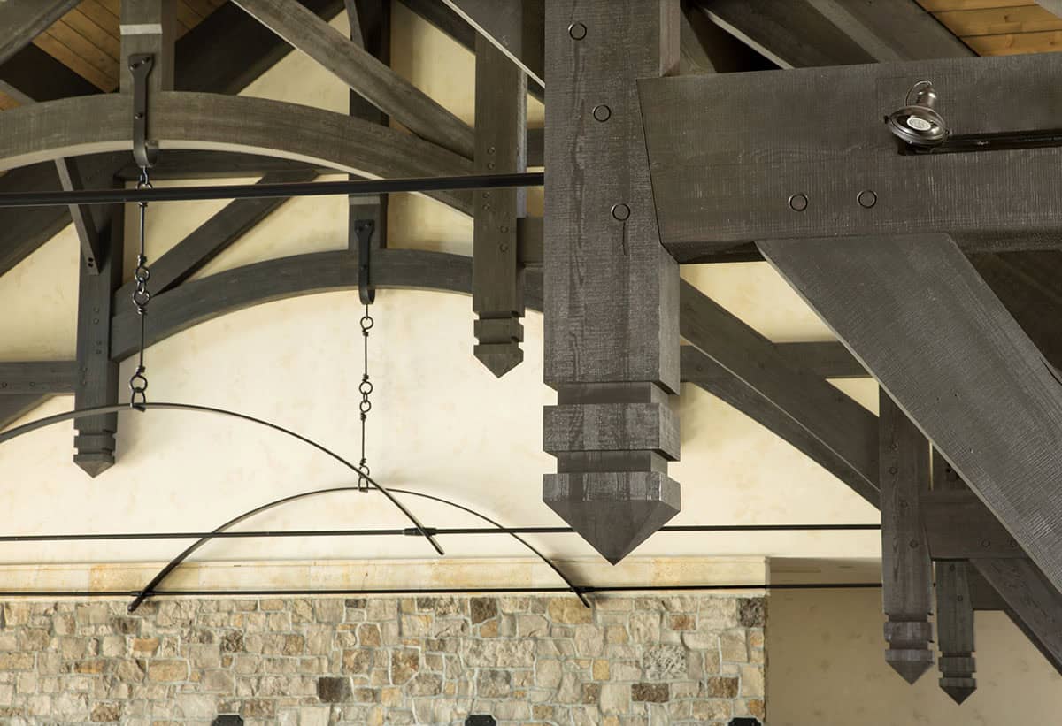 Close-up detail of structural wood truss joinery with decorative drop pendants