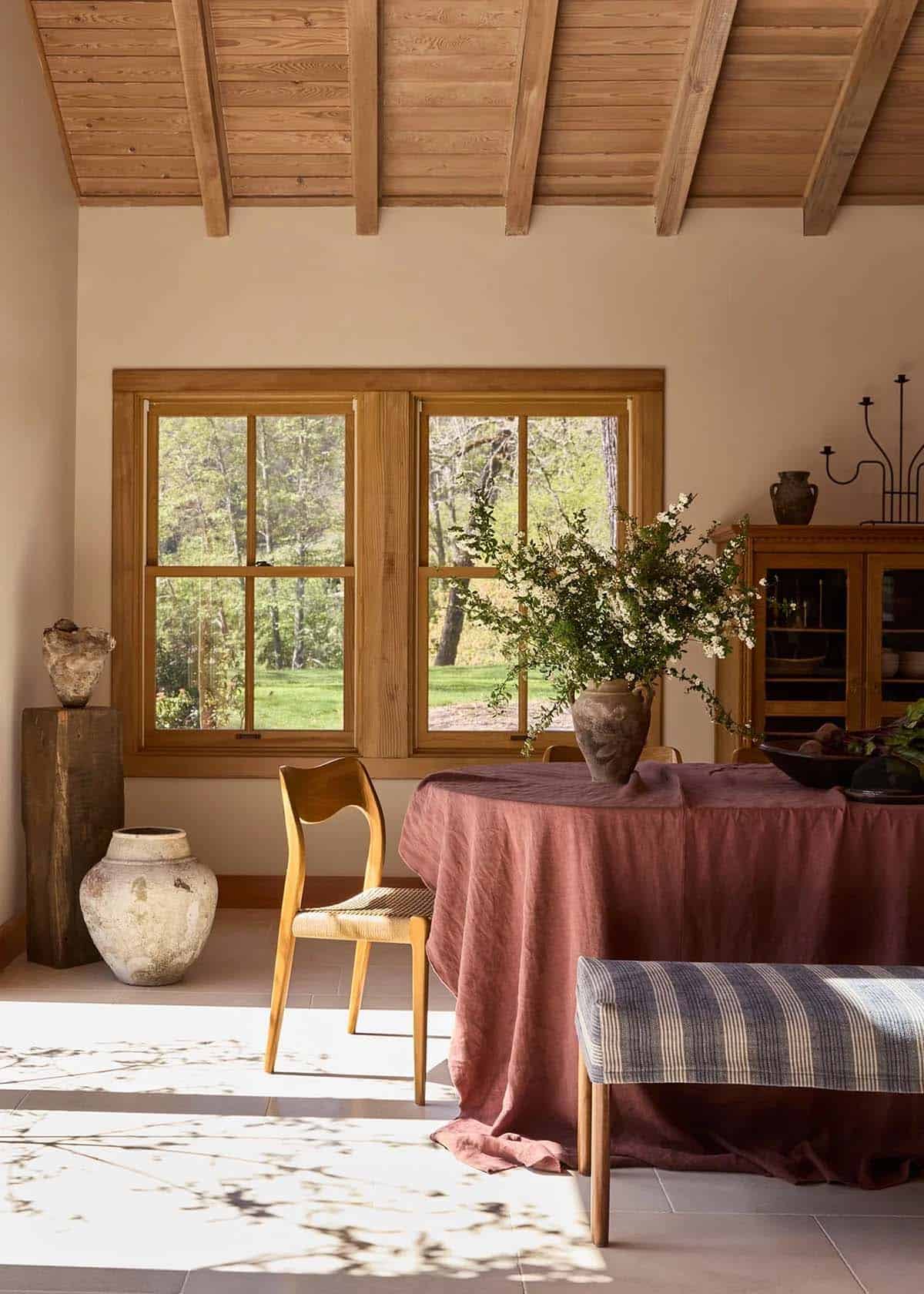 Dining room with wood beam ceiling, linen tablecloth, and vineyard views
