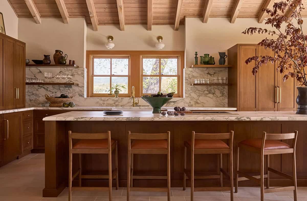Walnut kitchen with marble island, open shelving, and brass hardware