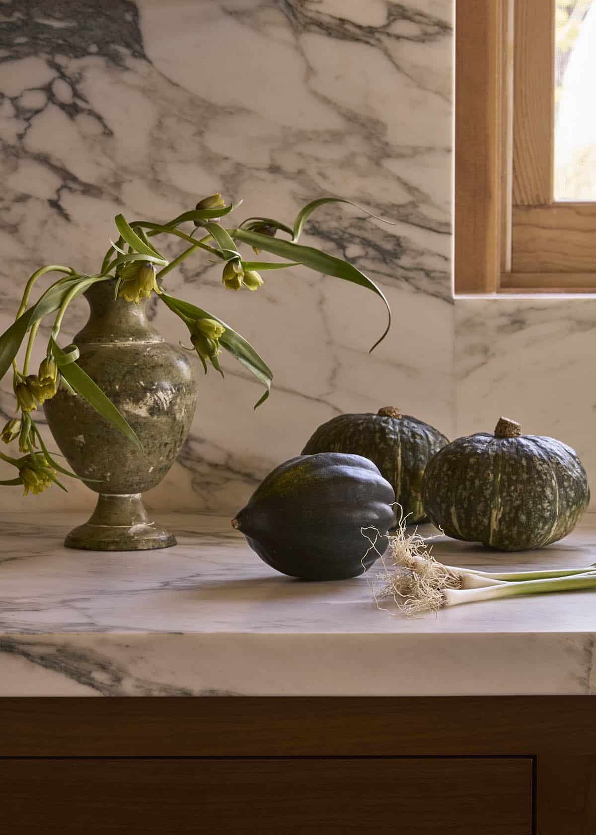 Marble kitchen counter with antique vase and seasonal squash
