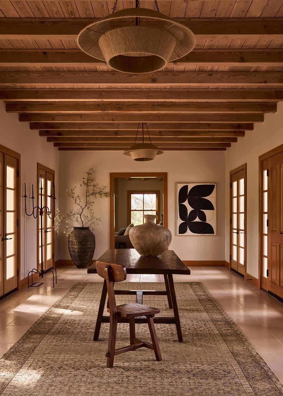 Foyer with exposed wood beam ceiling, jute pendants, and vintage console table
