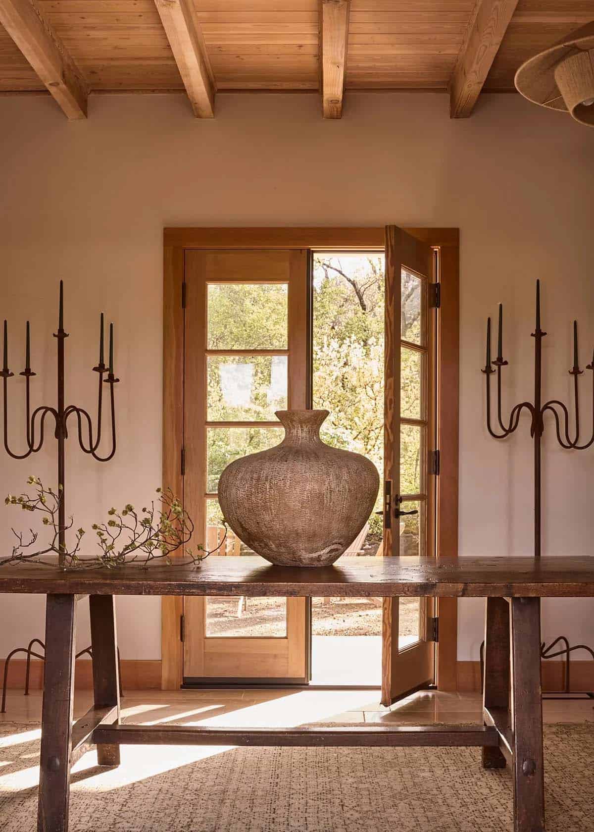 Entryway console with woven ceramic vase and iron candelabras