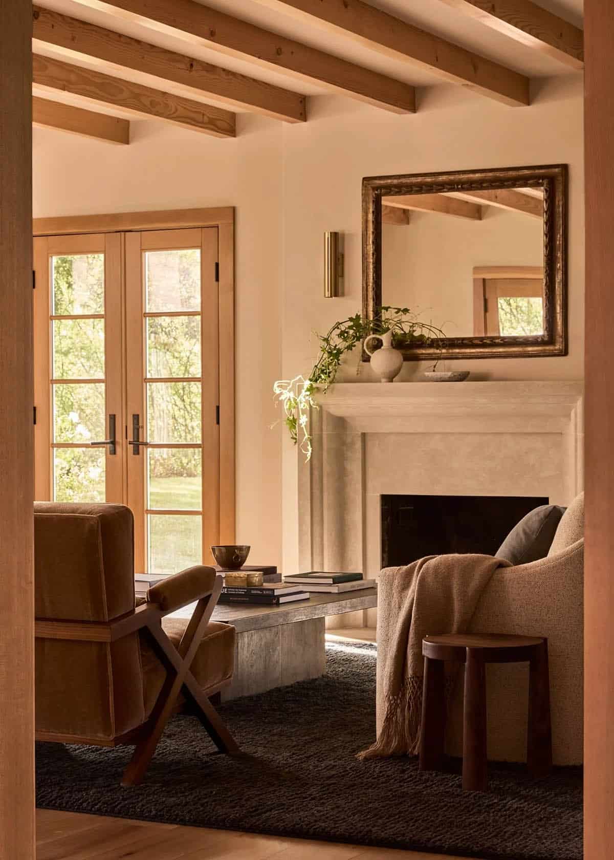 Living room with plaster fireplace, gilt mirror, and French doors to garden