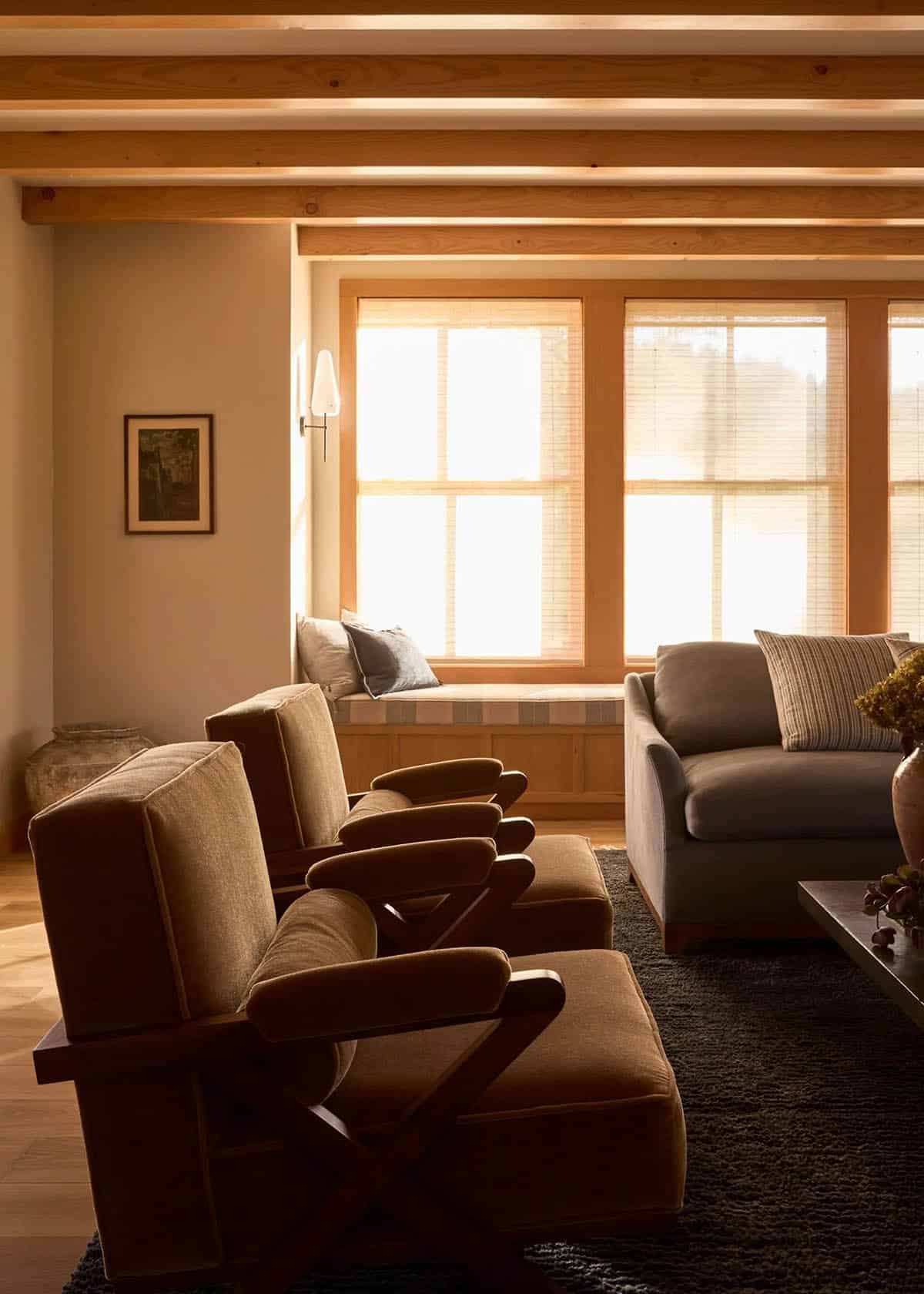 Living room seating area with wood beam ceiling and window seat
