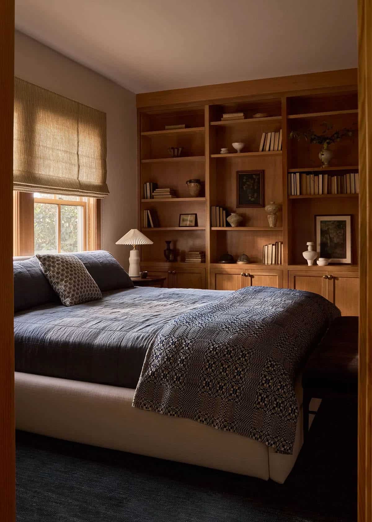 Guest bedroom with floor-to-ceiling walnut built-in bookshelves
