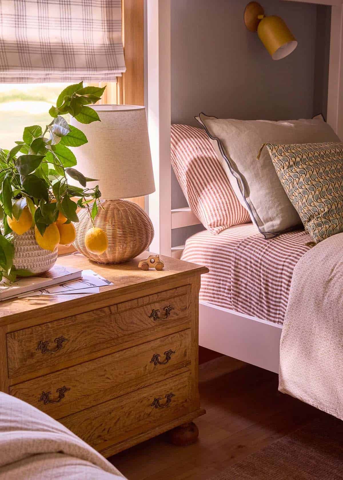 Kids bedroom with built-in bunks, striped bedding, and oak nightstand