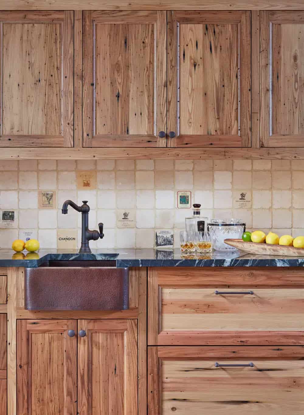 Historic waterfront house butler's pantry with reclaimed wood cabinetry, hammered copper farmhouse sink and wine label tile backsplash in Maryland