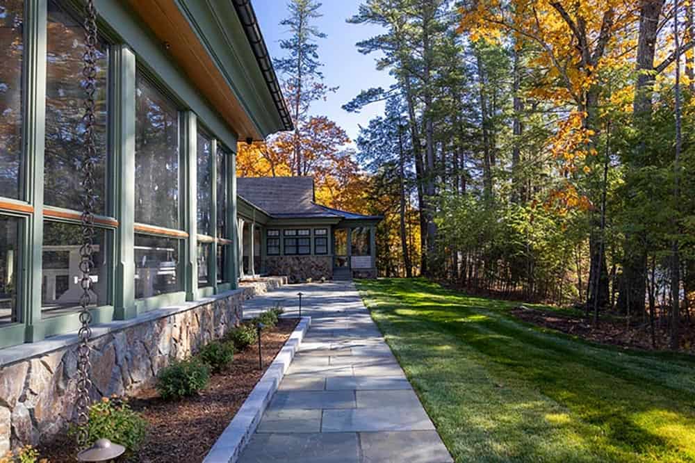 Flagstone walkway alongside screened porch with rain chains and fall foliage
