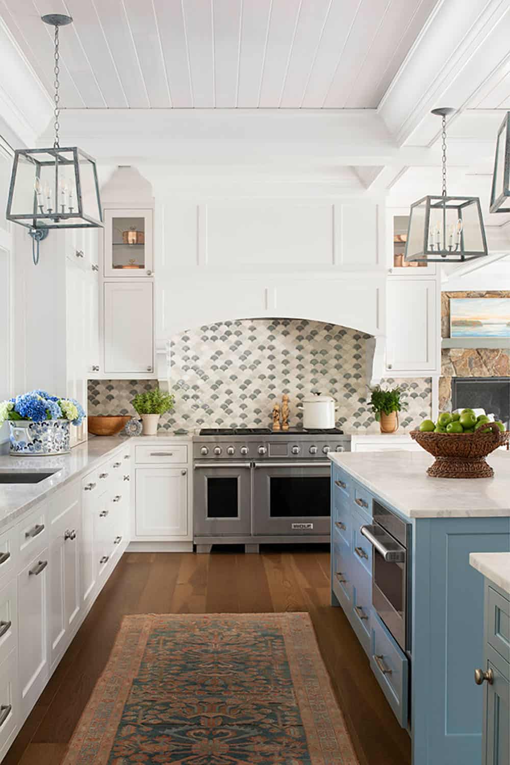 Kitchen with Wolf range, fish-scale tile backsplash, blue island, and shiplap ceiling