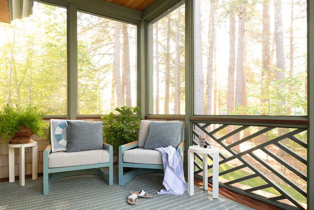 Private screened sleeping porch with teal lounge chairs and forest views