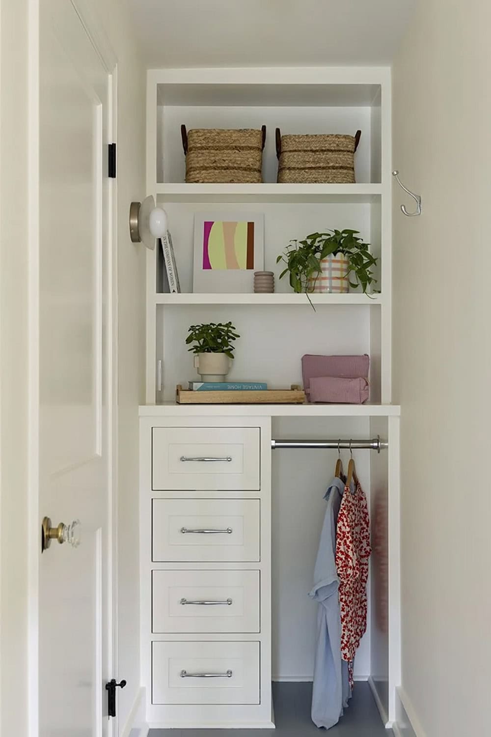 White built-in closet with open shelving, four-drawer dresser, hanging rod, and colorful art print