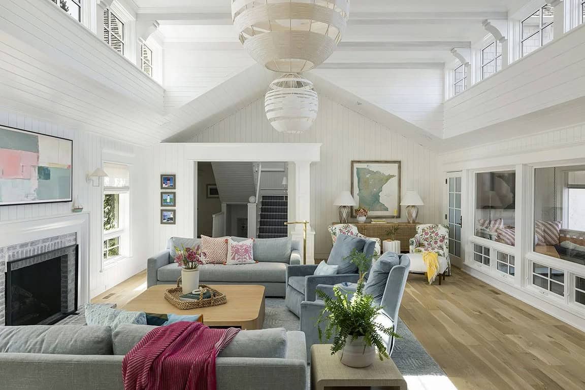 Great room with vaulted shiplap ceiling, multiple seating areas, woven globe pendants, fireplace, and Minnesota map art
