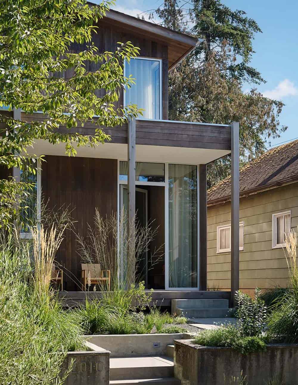 Close-up of the front porch entry with tall ornamental grasses and vertical cedar siding