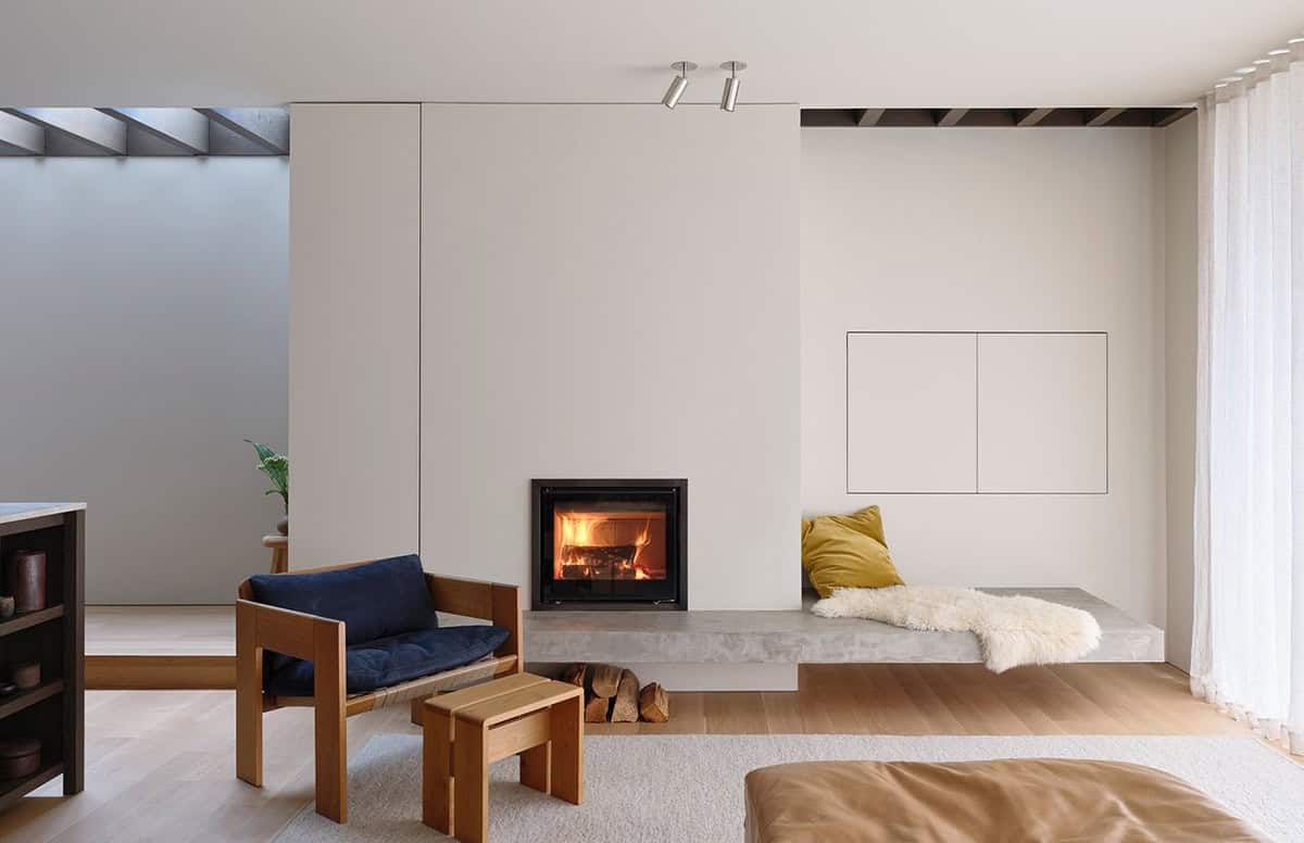 Living room with minimalist fireplace, built-in window seat, and custom wood furniture
