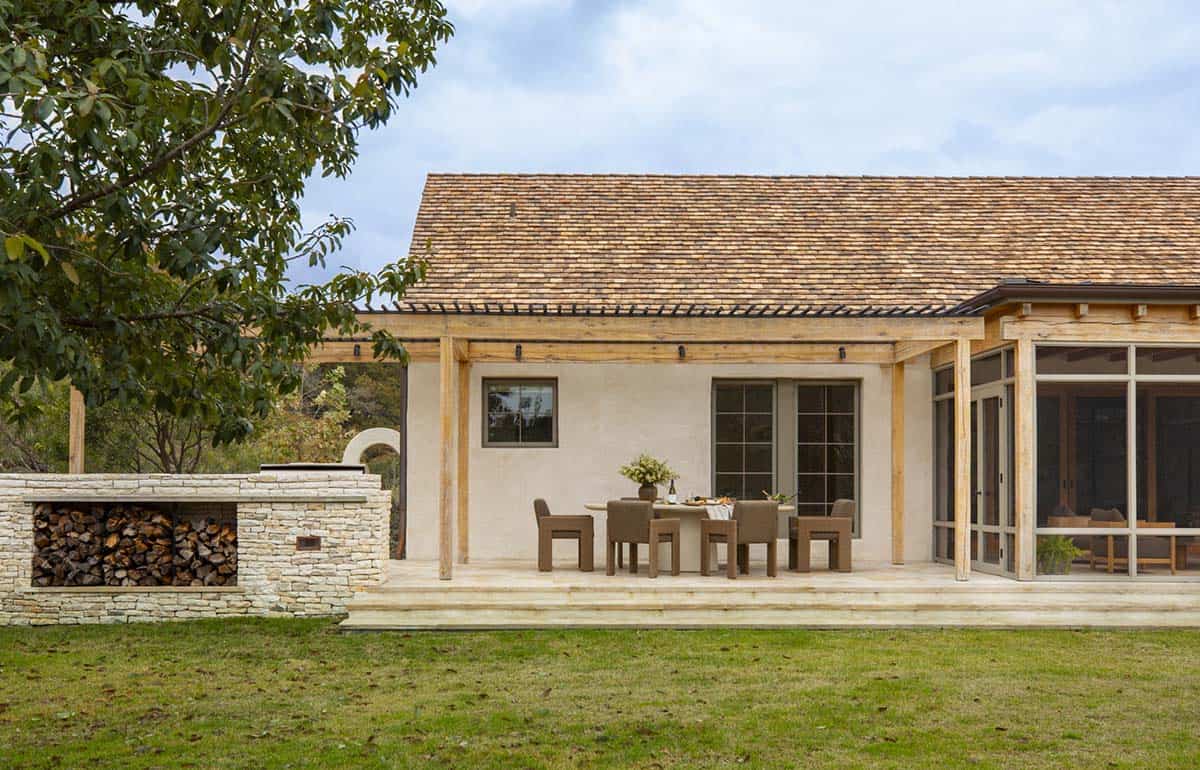 Back exterior with cedar shake roof, wood pergola, covered outdoor dining area, limestone fireplace, and screened porch