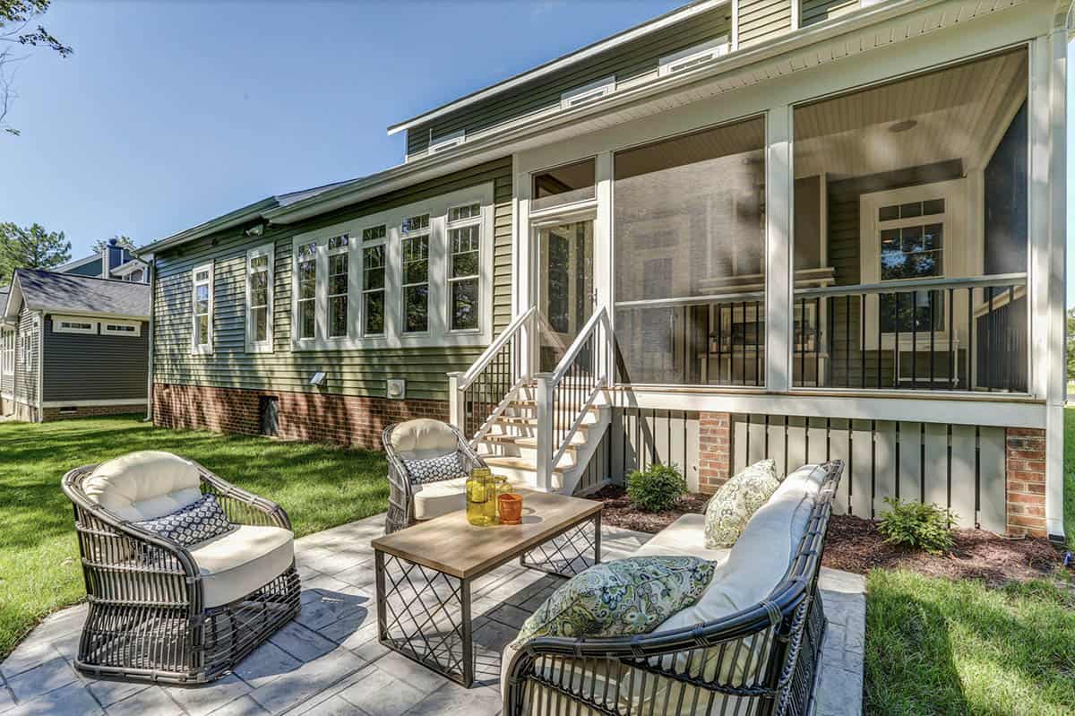 Back patio with wicker seating, stamped concrete, and screened porch addition