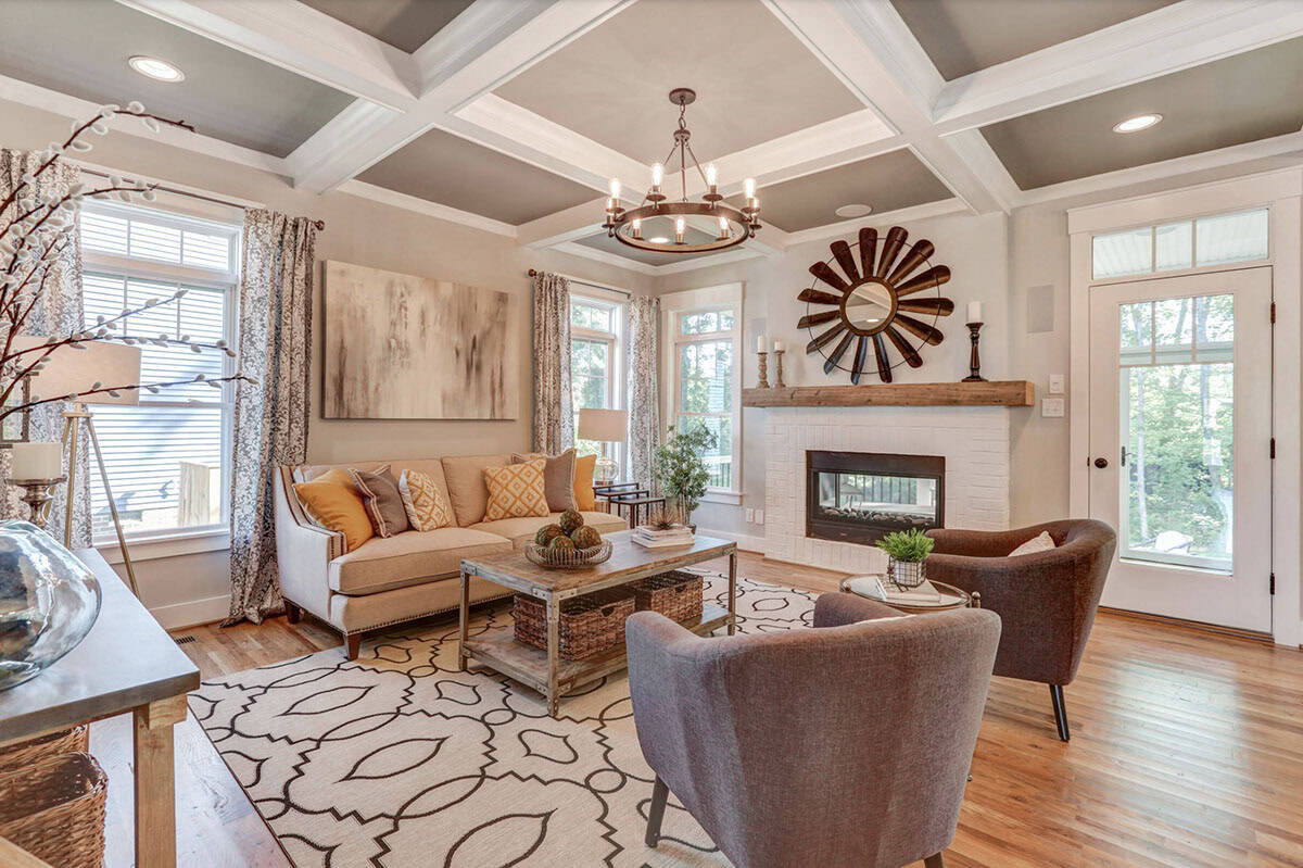 Living room with coffered ceiling, white brick fireplace, rustic wood mantel, and warm neutral furnishings