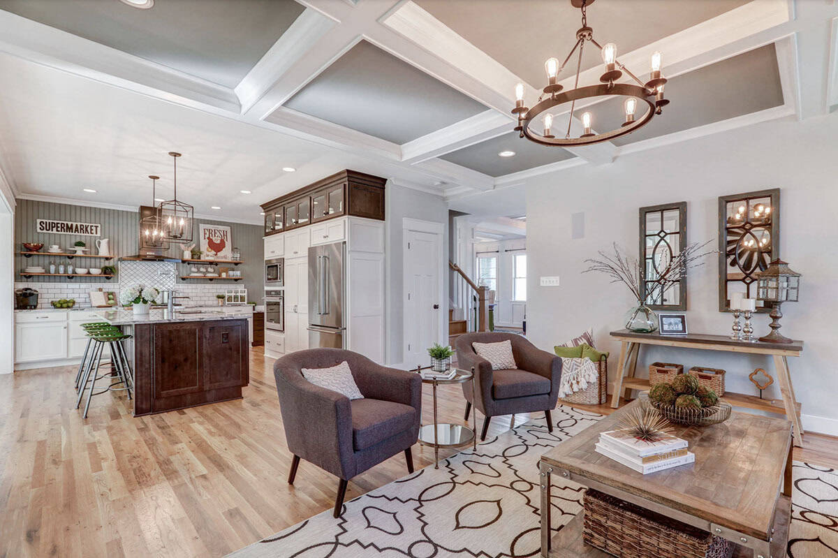 Great room looking toward farmhouse kitchen with white cabinets, open shelving, and dark island