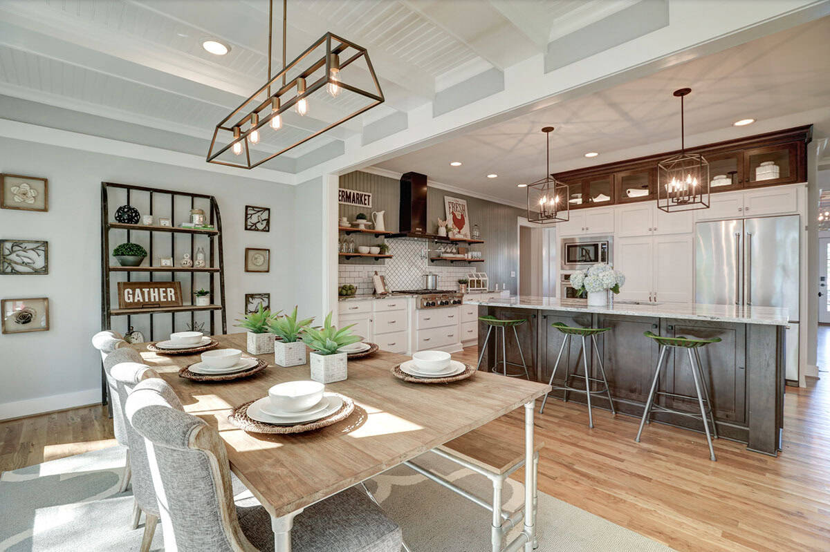 Open-plan breakfast nook and kitchen with industrial pendant lighting, pipe-leg dining table, and dark wood island