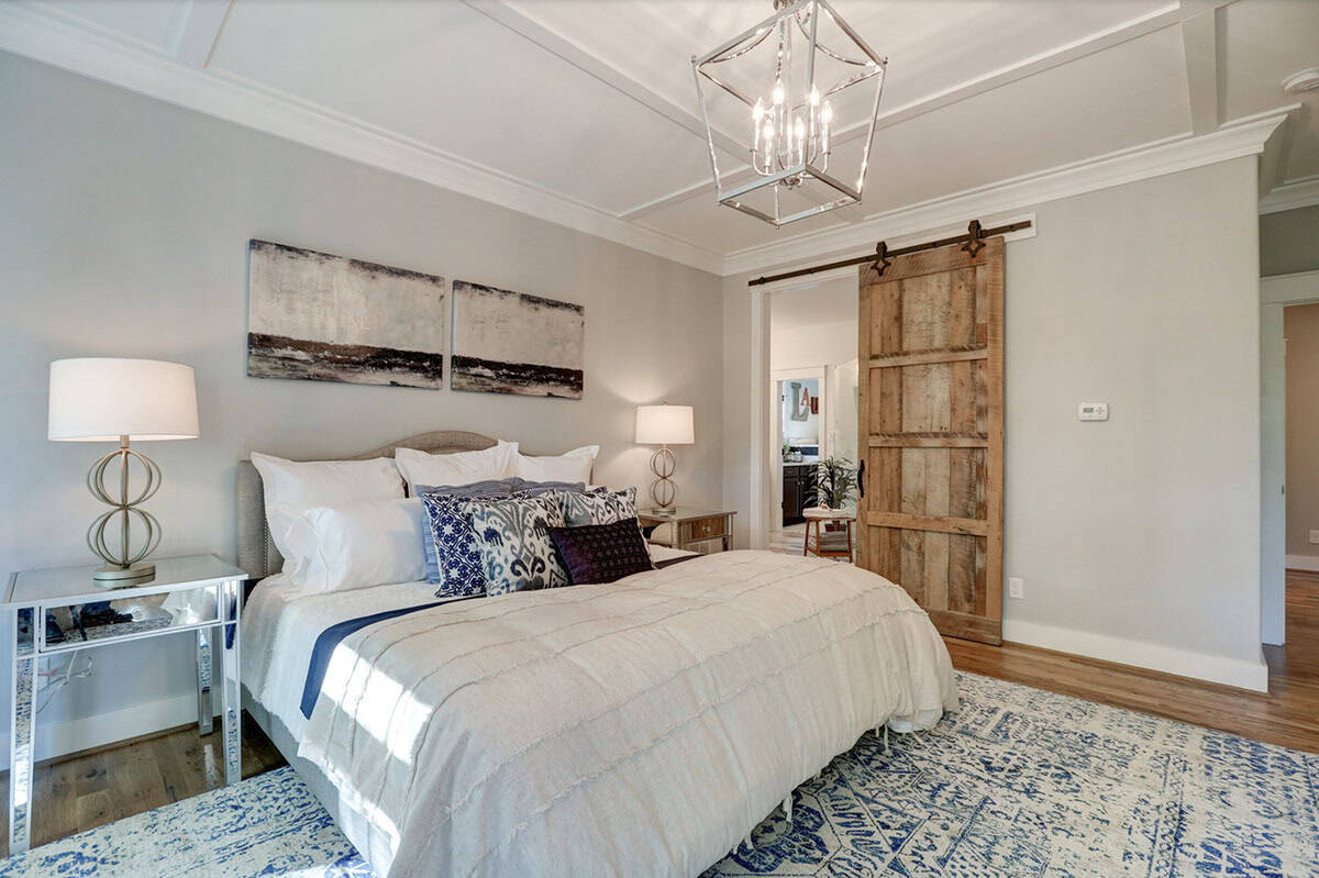 Primary bedroom with reclaimed wood sliding barn door leading to ensuite bathroom