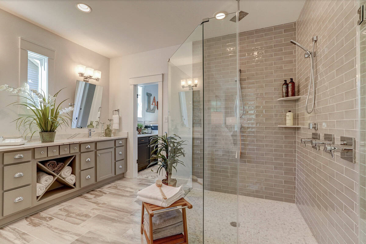 Primary bathroom with double vanity, gray cabinetry with towel cubbies, and large glass walk-in shower