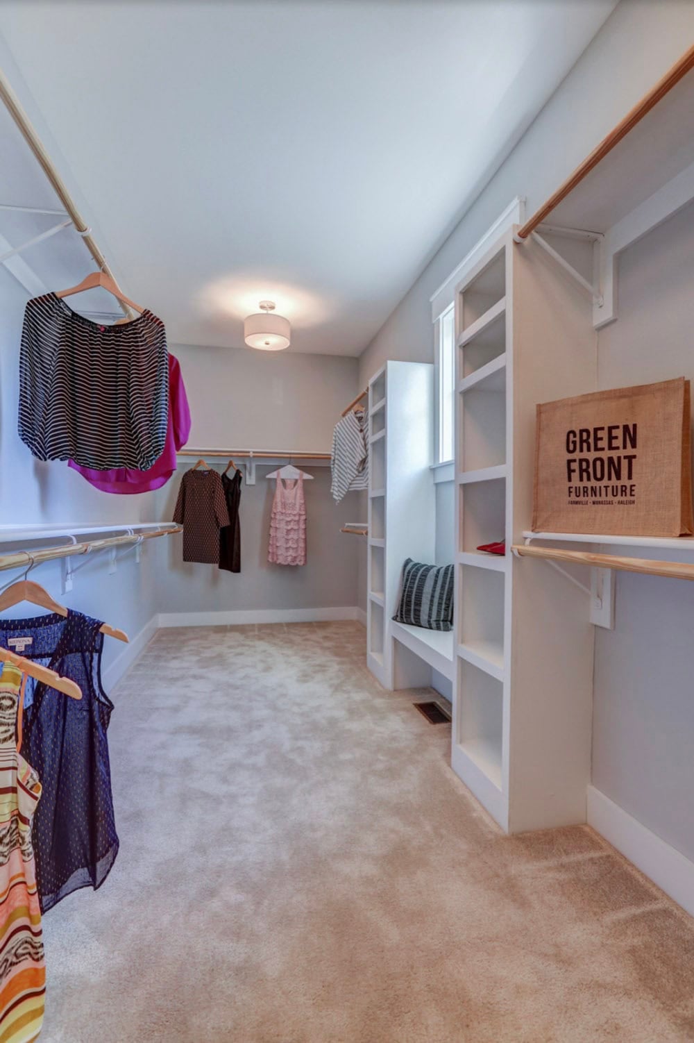 Spacious walk-in closet with built-in shelving, double hanging rods, and carpet flooring