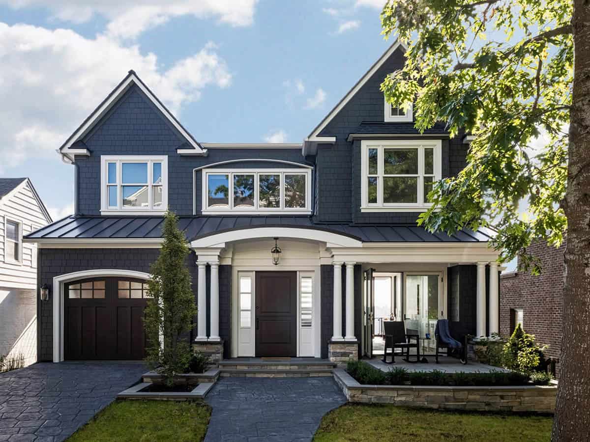 Modern craftsman home exterior with dark navy shingle siding, white columns, and arched portico