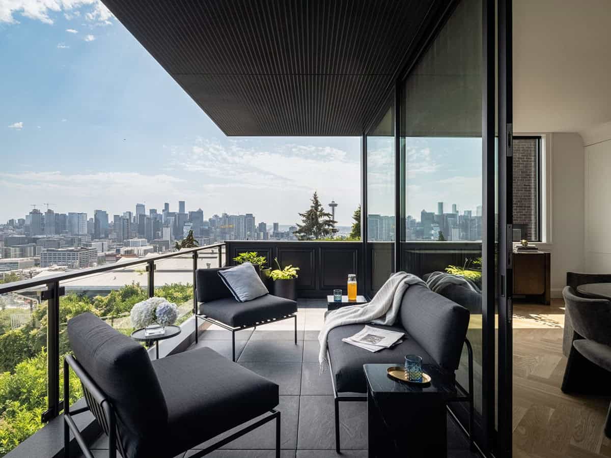 Modern outdoor terrace with dark lounge furniture and sweeping Seattle skyline panorama