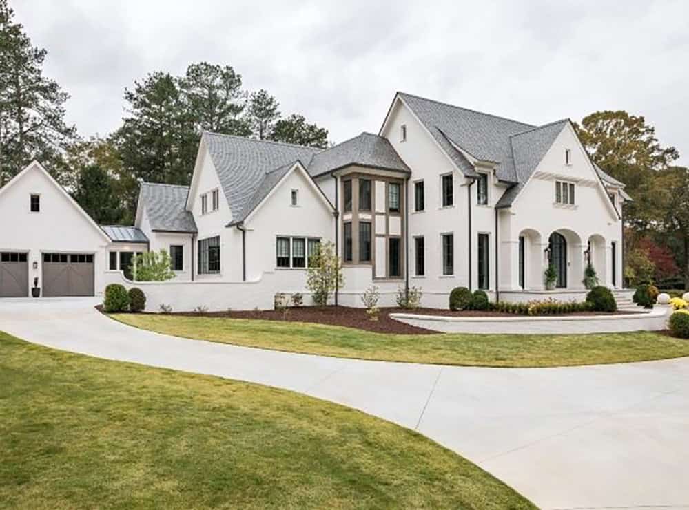Modern English country house side exterior with U-shaped plan, cedar-framed window wall and curved driveway in Georgia