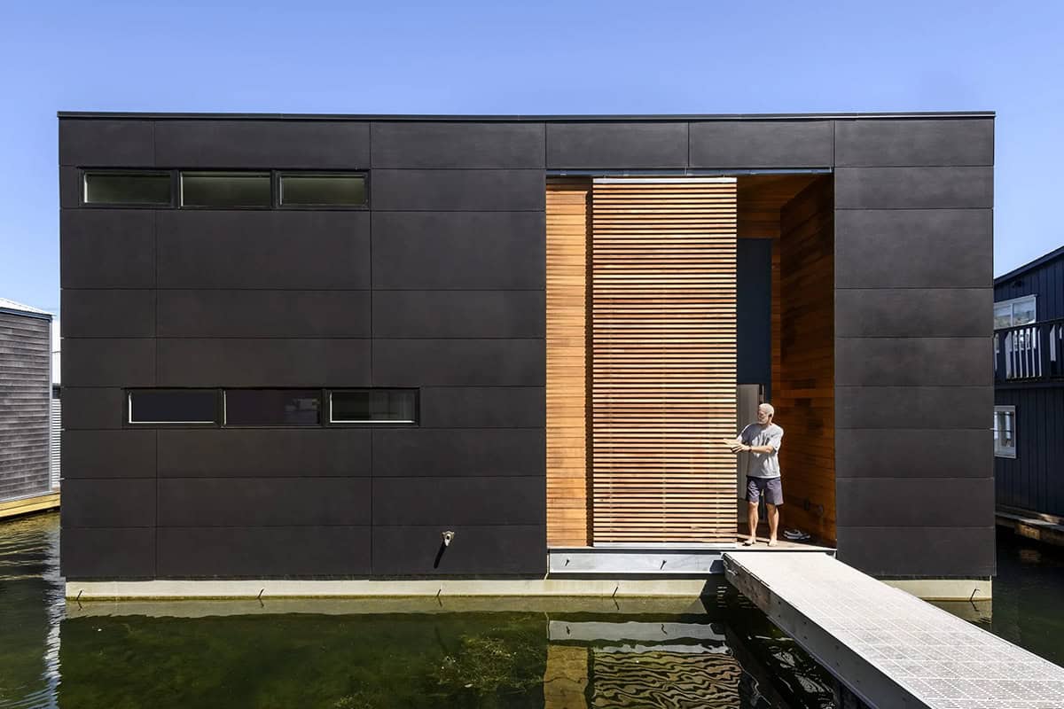 Modern floating home exterior with dark panel cladding and cedar screen on Portage Bay, Seattle