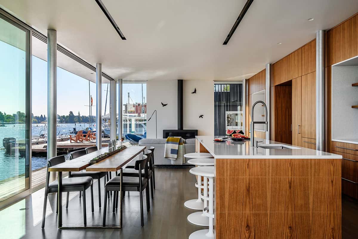 Open-plan kitchen, dining, and living area with floor-to-ceiling water views