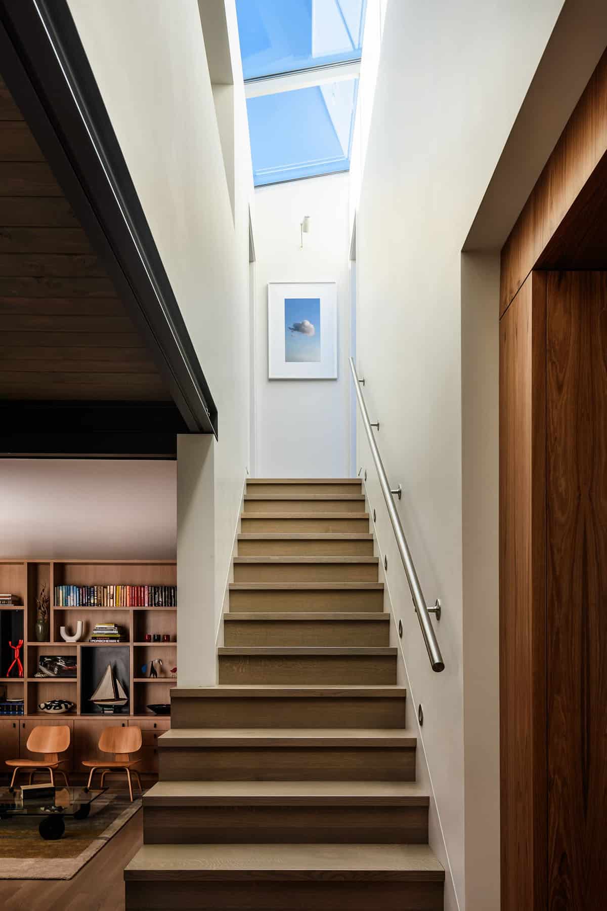 Floating home staircase with skylight and framed cloud photograph